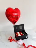 Caja sorpresa con flores, bombones, fresas con chocolate y globo metalizado con helio