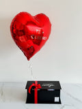 Caja sorpresa con flores, bombones, fresas con chocolate y globo metalizado con helio